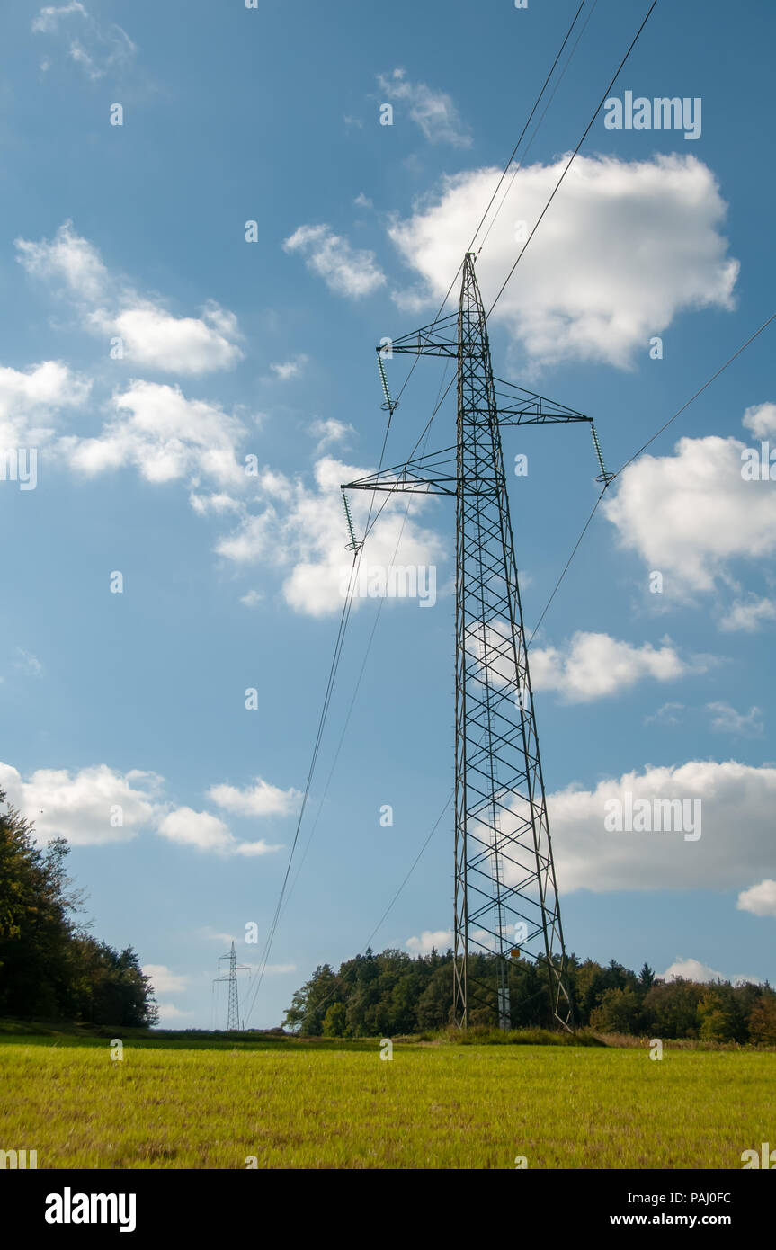 High voltage lines and power pylons innatural landscape on blue sky ...