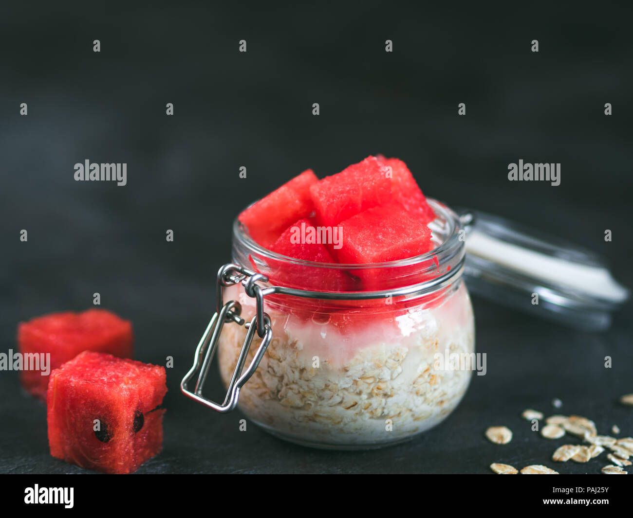 Healthy breakfast overnight oats with watermelon pieces in glass jar. Overnight oatmeal