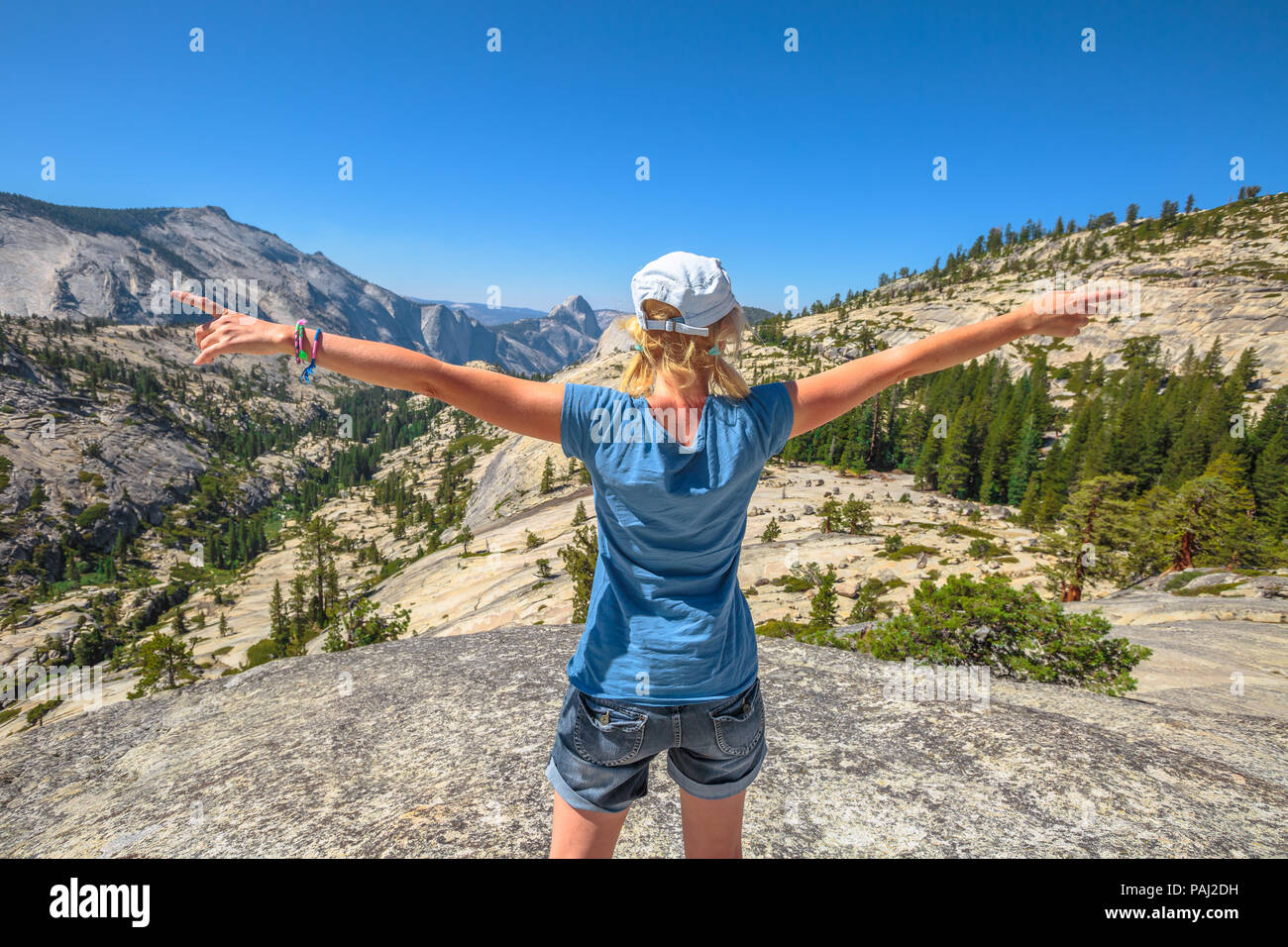 Hiking woman enthusiastic with open arms at Olmsted Point. Tired hiker resting happy and taking a breath after hiking. Caucasian female in Yosemite National Park, California, United States. Stock Photo