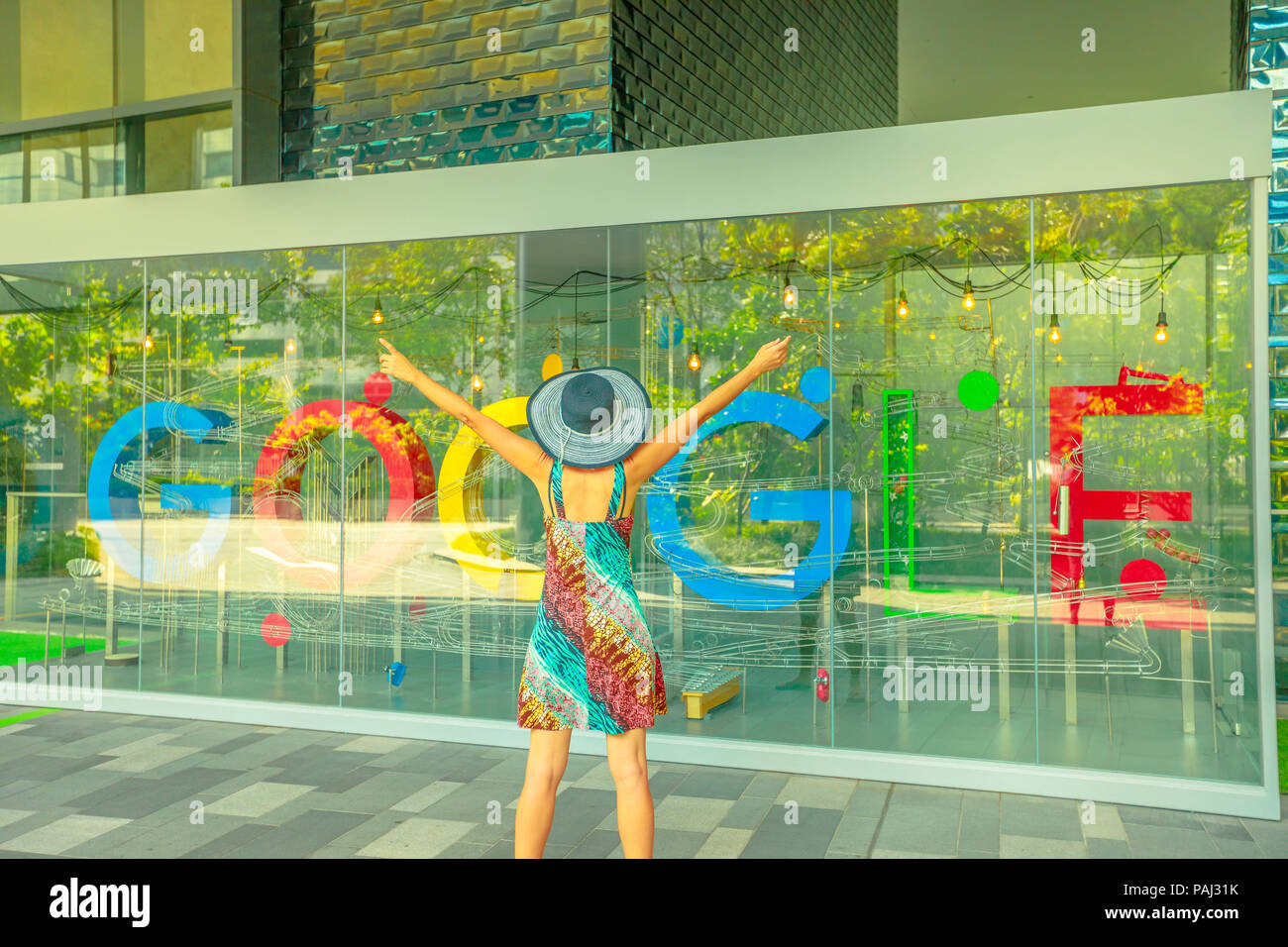 Singapore - Maggio 5, 2018: woman enjoying at Google sign on lobby of new Google Headquarters, Mapletree Business City II in Singapore. Google's Asia-Pacific HQ spans the entirety of blocks 60 to 70. Stock Photo