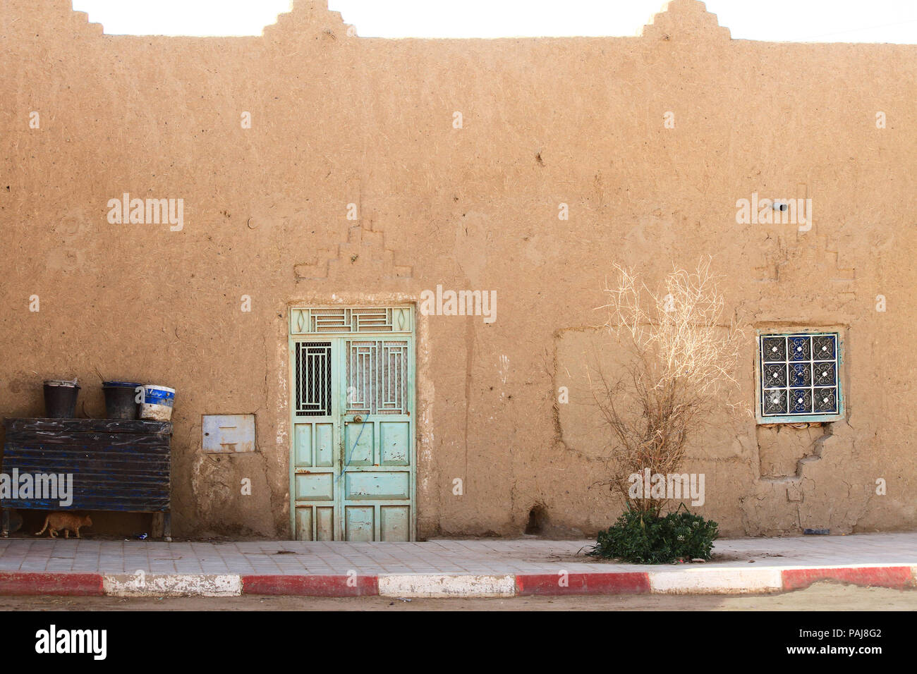 Village traditional house with pastel green steel doors on sunny day. Sahara Desert. Morocco, Africa. Stock Photo