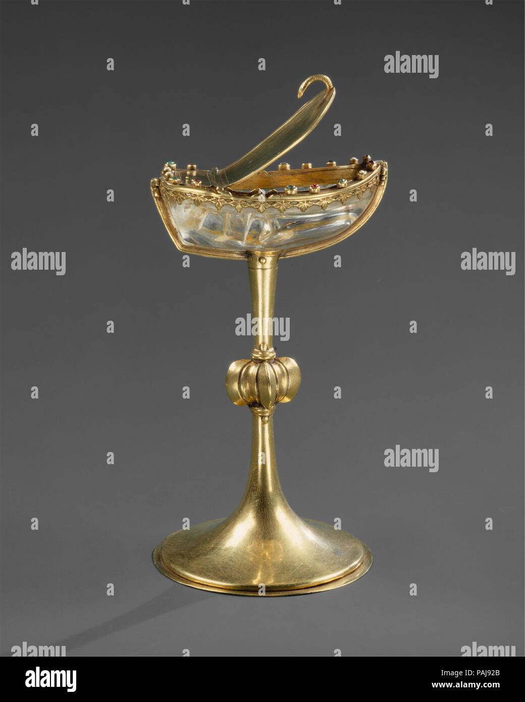 Saltcellar. Culture: French. Dimensions: H. 5 1/2 in. (14 cm); Diam. of  foot: 3 1/8 in. (7.9 cm). Date: mid-13th century.  Refined design, exquisite craftsmanship, and costly materials make this a rare and unusually precious object. The rock crystal, cut in the shape of a boat, may have served as a container for salt. Such table objects are described in several French royal inventories. The attribution is supported by the similarity of design to other mid-thirteenth century objects ascribed to Paris, a preeminent center of goldsmithing and carved crystal work. Museum: Metropolitan Museum of A Stock Photo