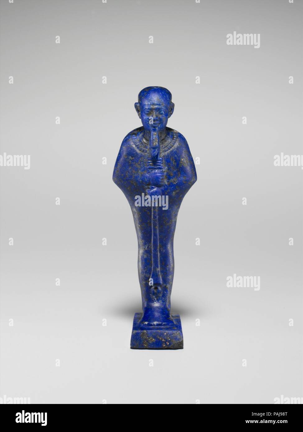 Cult Image of the God Ptah. Dimensions: Height of figure 5.2 cm (2 1/16 in); w. 1.8 cm (11/16 in); d. 1.1 cm (7/16 in.); Height of dais 0.4 cm (3/16 in); w 1.0 cm (3/8 in); d 1.6 cm (5/8 in). Date: ca. 945-600 B.C..  This statuette depicts Ptah, the chief god of Egypt's capital city Memphis, who is easy to identify by his tight-fitting cap and enveloping shroud.  Other iconographic details, such as the royal beard, the large and detailed broad collar, the scepter of merged 'was' and 'djed' signs, and a platform representing the hieroglyph for universal order, as well as the brilliant blue ston Stock Photo