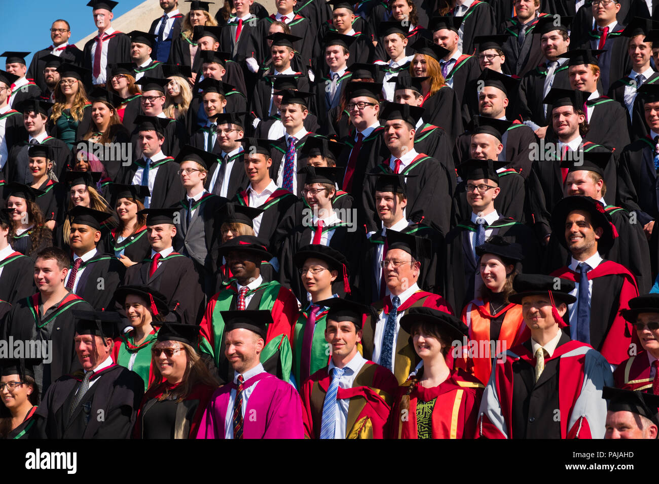 Higher Education in the UK: Students graduating from Aberystwyth university, in their traditional mortar boards and black academic gowns, posing for their traditional group photograph. July 2018 Stock Photo