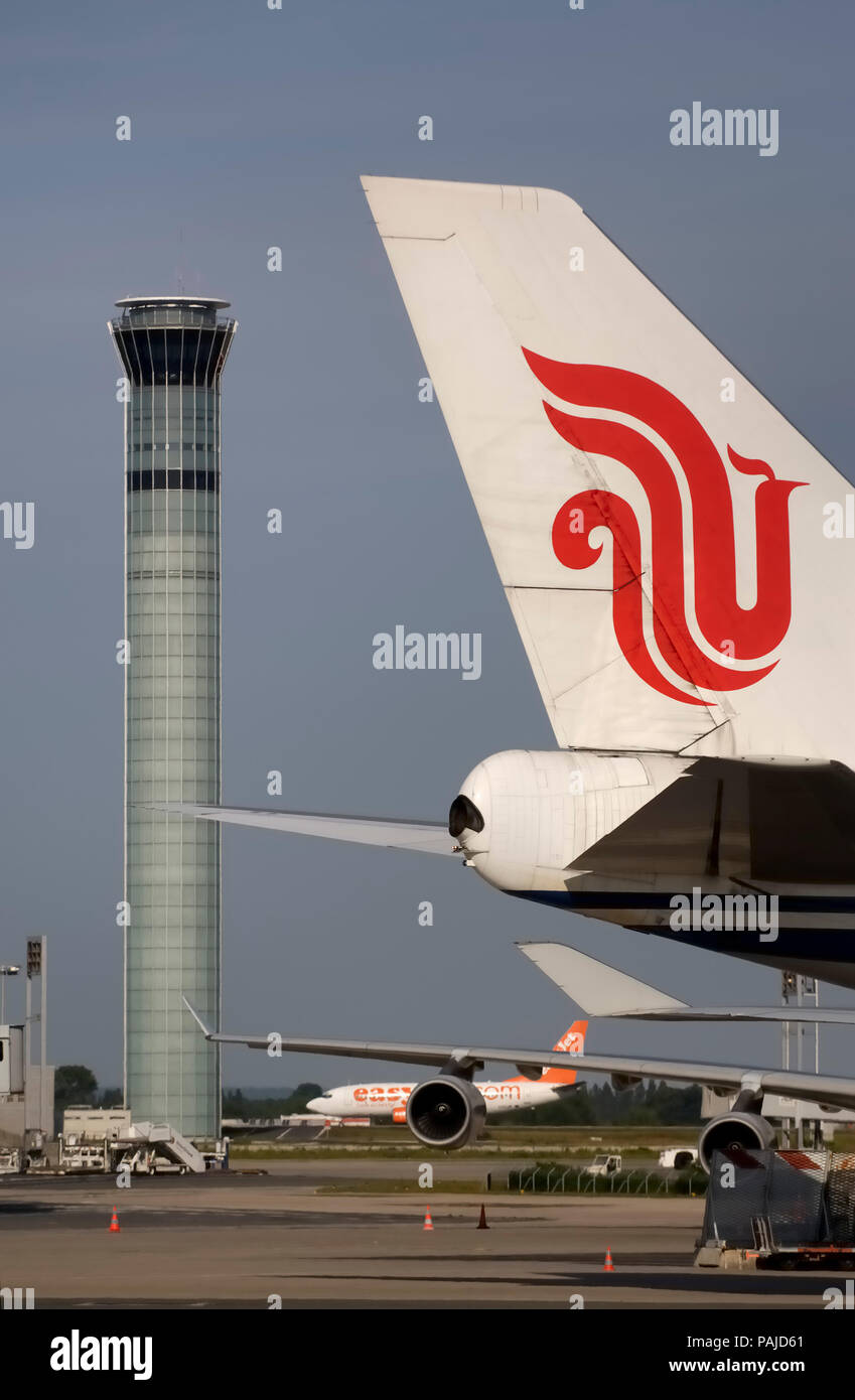 Air China tail with logo and B747-400 winglet with an easyJet 737 taxiing and control-tower behind Stock Photo