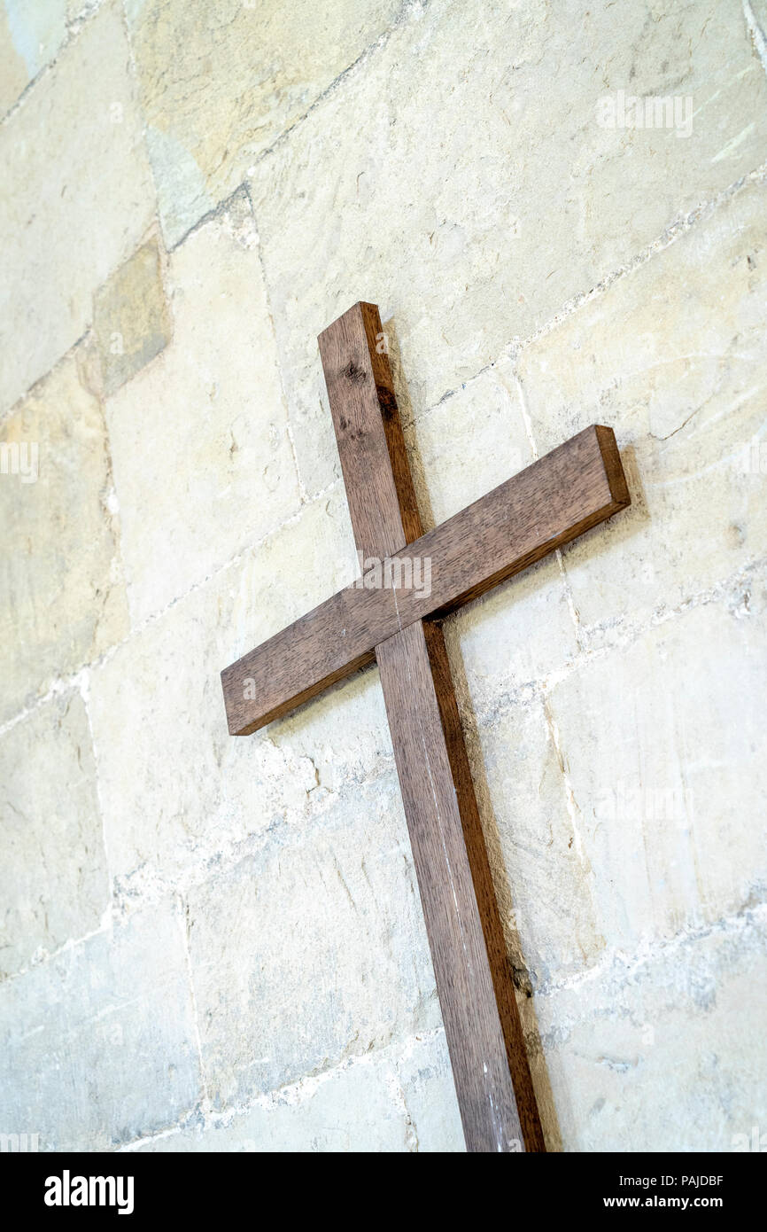 Wooden cross attached to a stone wall Stock Photo