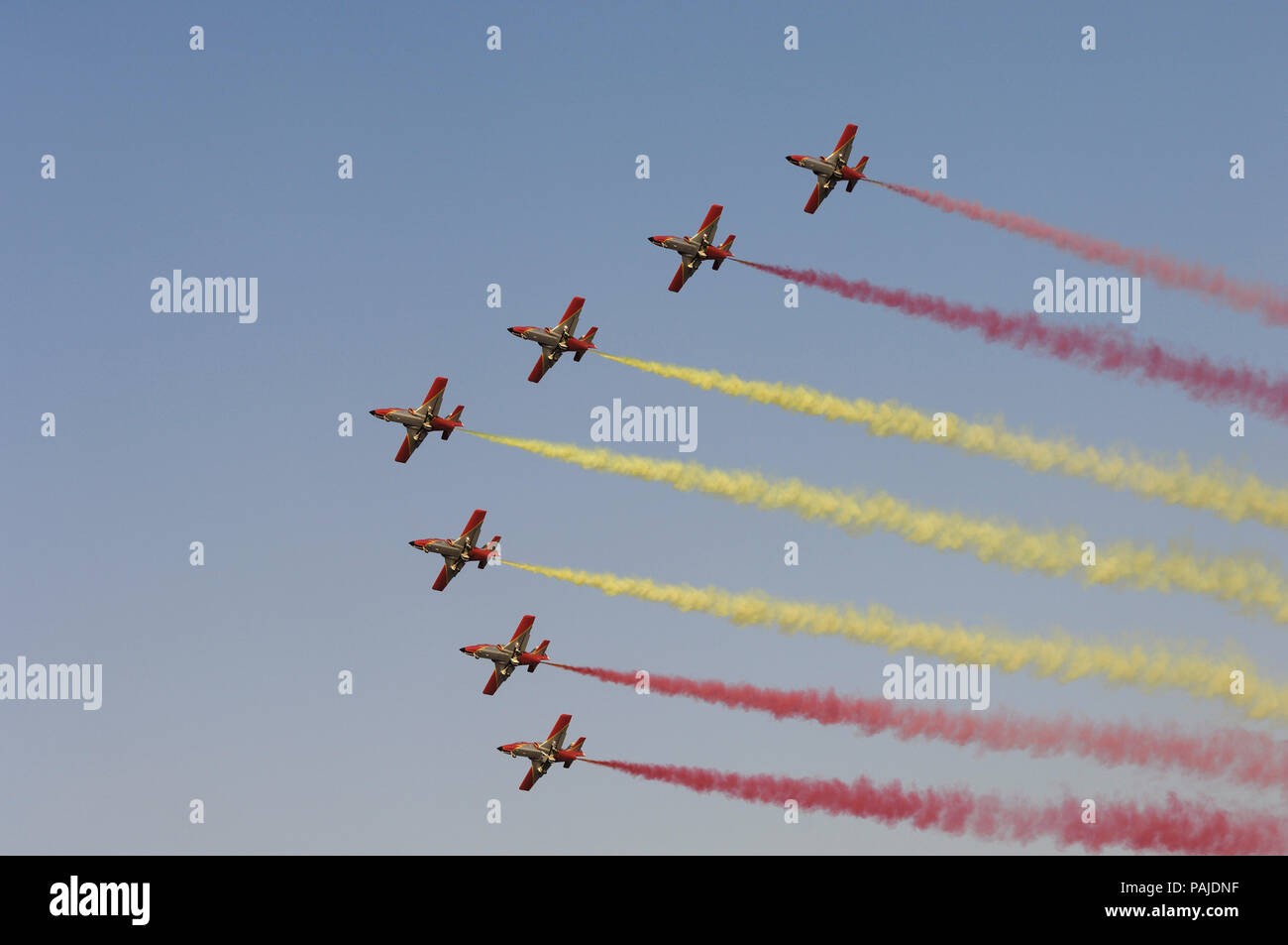 CASA C-101EB Aviojets of Spain - Air Force Patrulla Acrobatica Aguila flying in formation with red and yellow smoke at Dubai AirShow 2007 Stock Photo