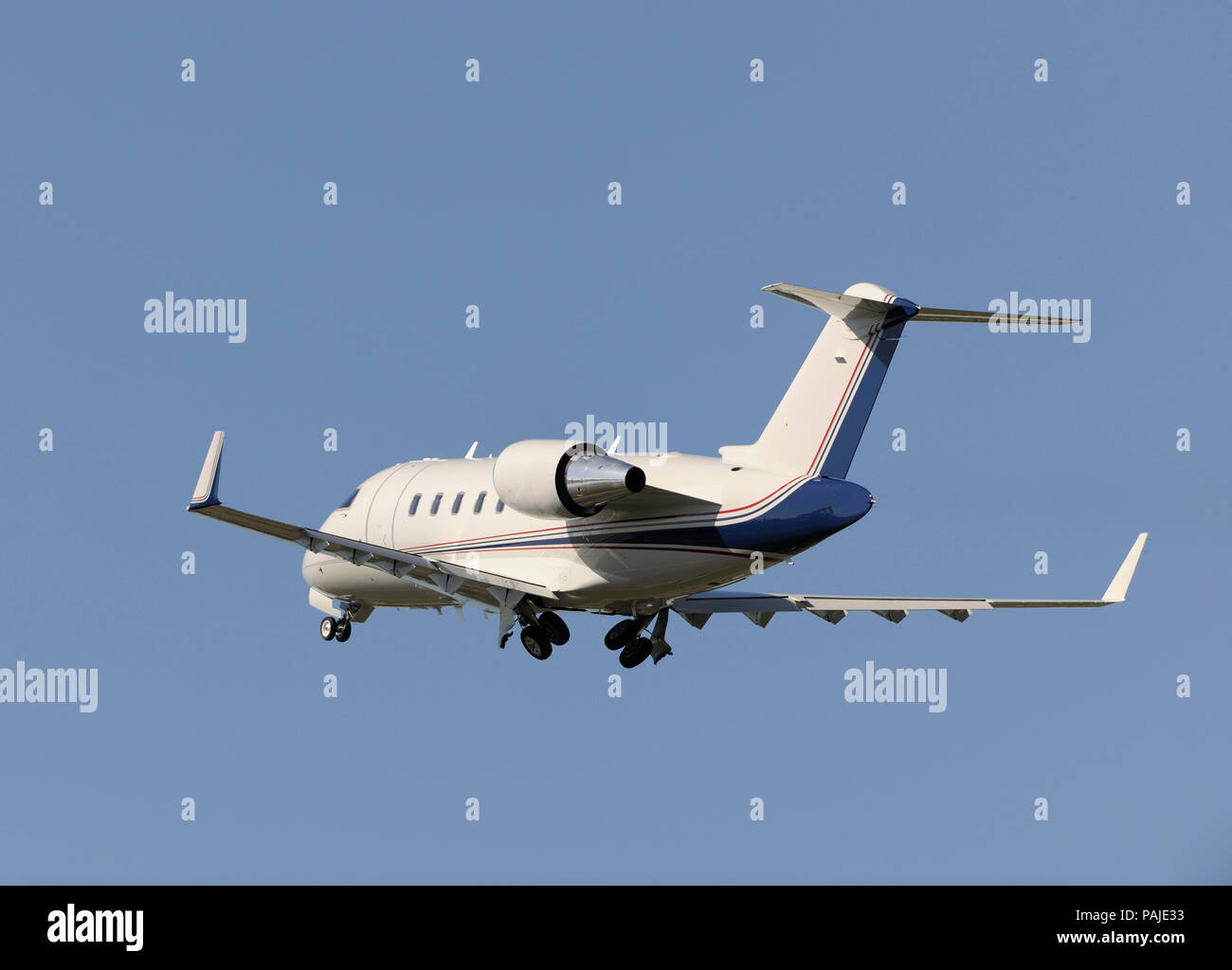 Boeing Company Bombardier Challenger 605 climbing out after take-off with undercarriage retracting Stock Photo