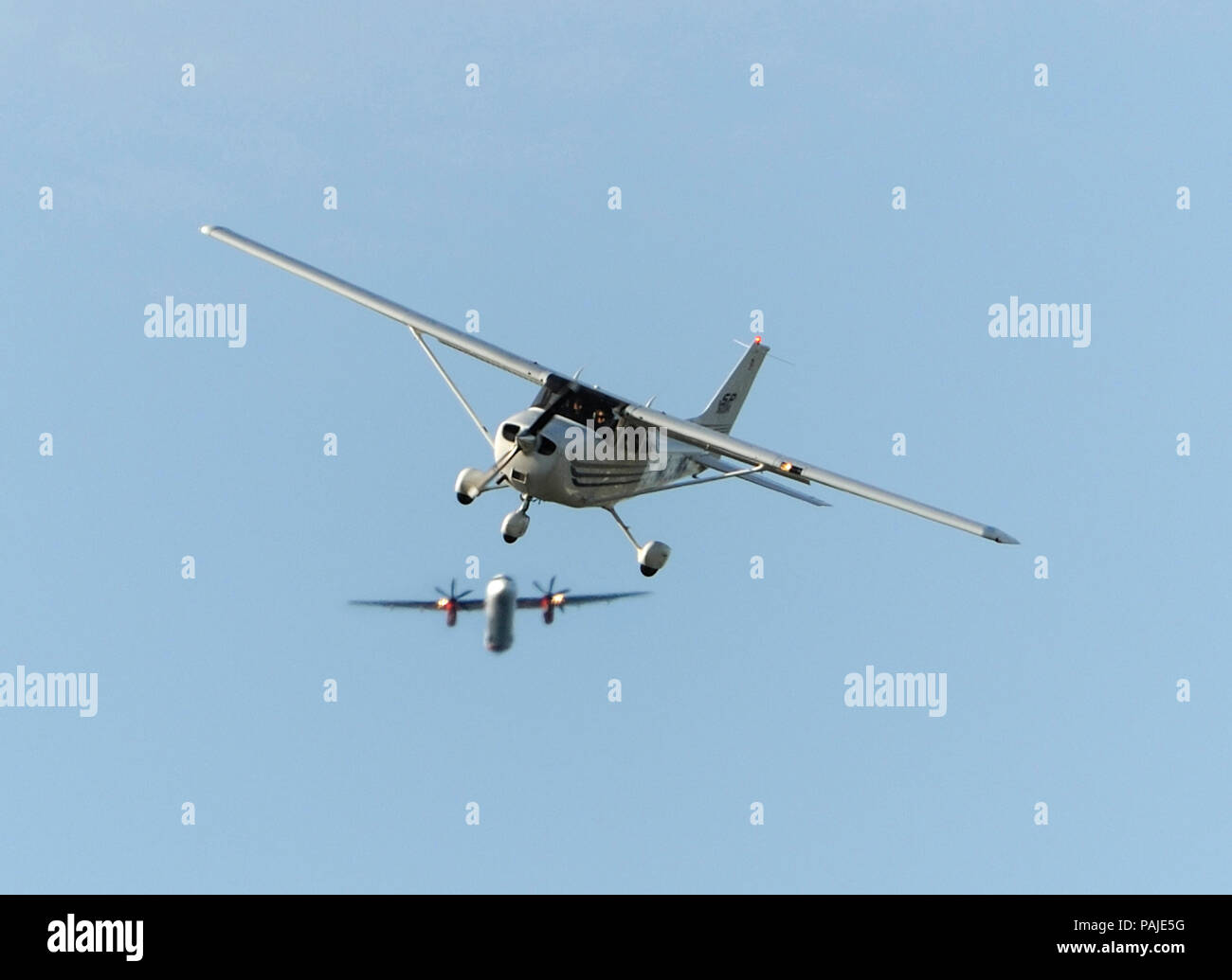 Cessna 172S Skyhawk on final-approach and Horizon Air Bombardier DHC-8 Q400 climbing out after take-off Stock Photo