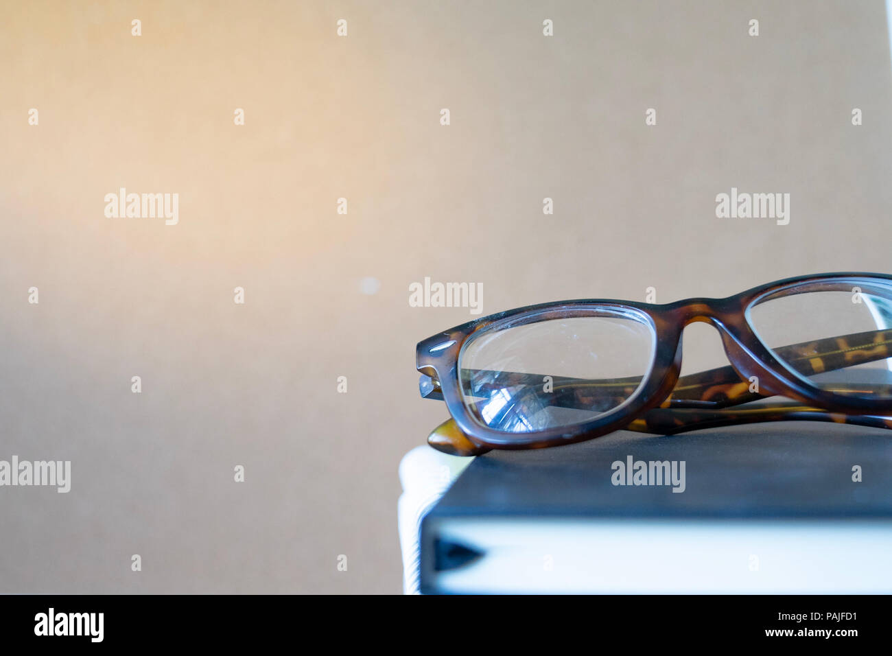 close up vintage glasses on blurred black book stack with copy space Stock Photo