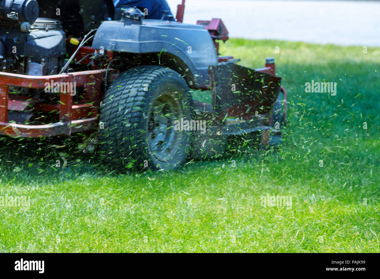Red Lawn mower cutting grass. Gardening concept Stock Photo