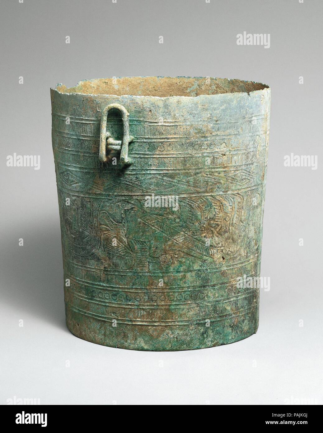 Situla with Design of Boats. Culture: Vietnam. Dimensions: H. 8 1/4 in. (21 cm). Date: ca. 500 B.C.-A.D. 300.  Axes, situlae, and drums play an important role in Vietnam's Dongson culture named after a site located on the coastline to the south of present-day Hanoi that was first excavated in 1924. The four long boats with seated warriors in the central horizontal band of this bucket shaped vessel, common images in the art of the Dongson culture, are also depicted, albeit more summarily, on the sides on the bronze model of a drum in this case. There had been much speculation regarding the mean Stock Photo