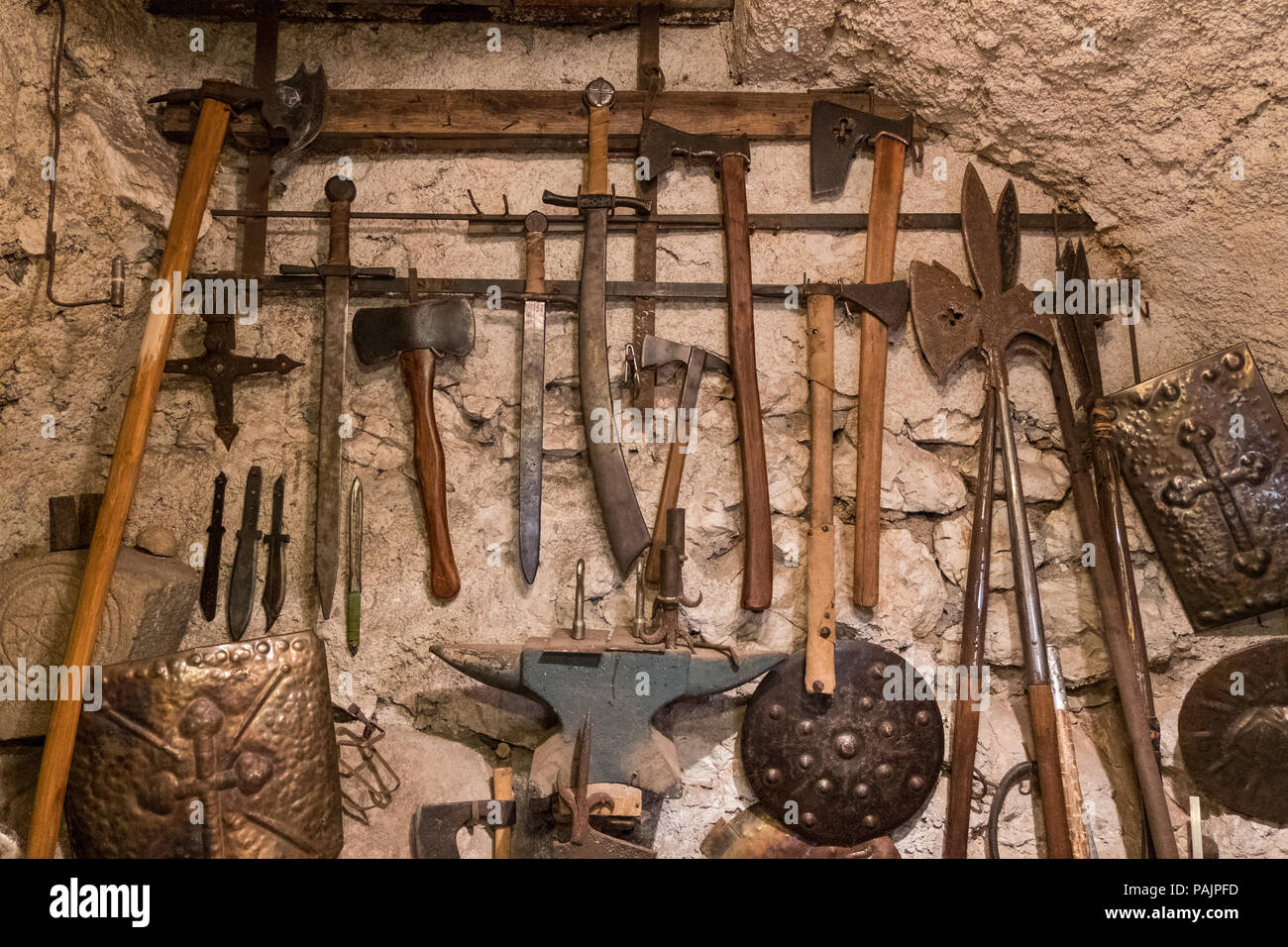 Wallpaper background of ancient medieval weapons hanged on a vintage stone and concrete wall. History of war. Stock Photo