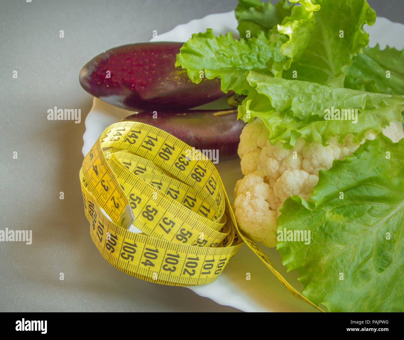 Diet concept, healthy eating, lettuce, cauliflower eggplant measuring tape vegetables Stock