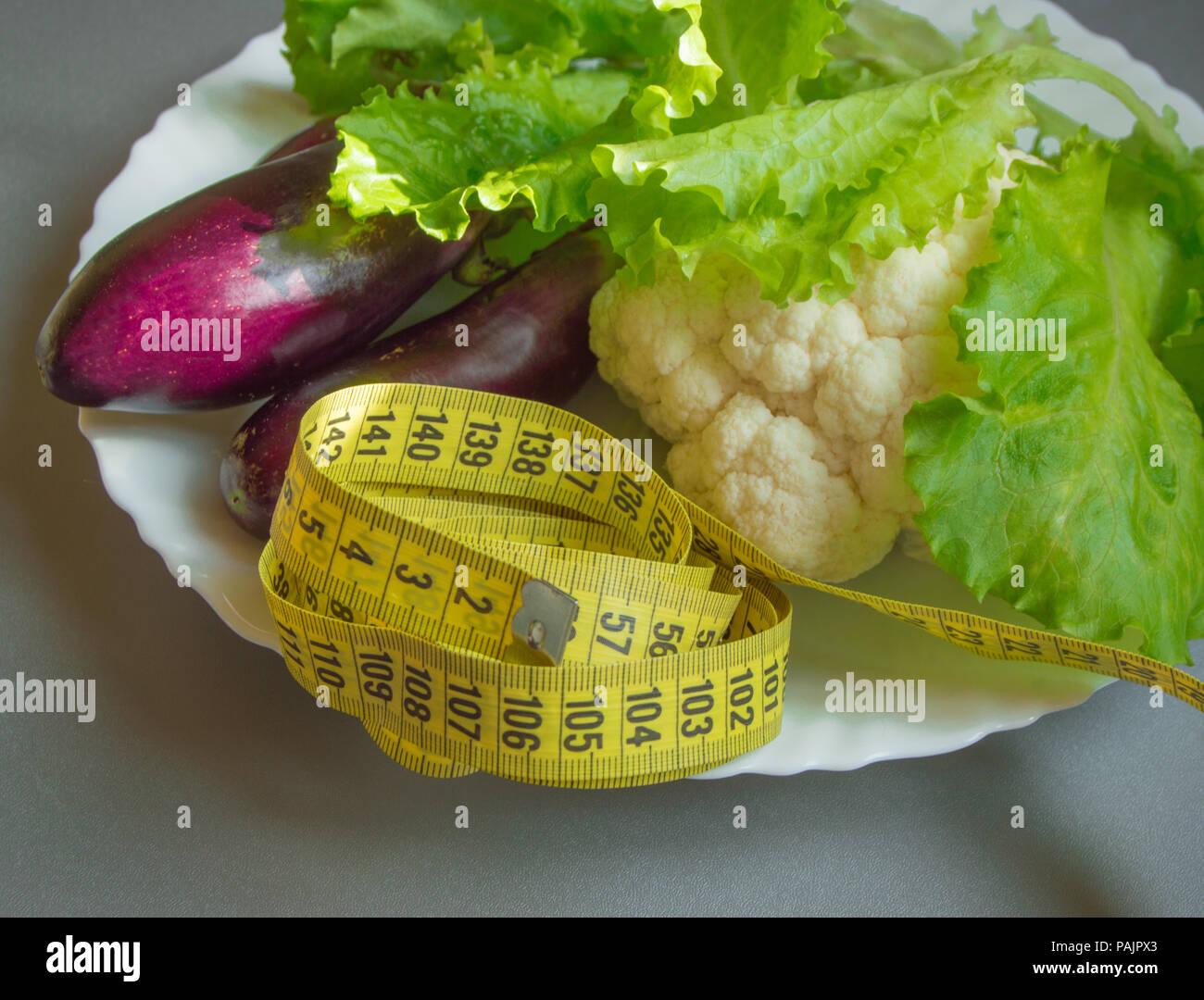 Diet concept, healthy eating, lettuce, cauliflower eggplant measuring tape vegetables Stock