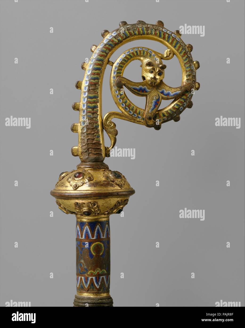 Head of a Crozier with a Serpent Devouring a Flower. Culture: French. Dimensions: 9 1/8 × 5 1/16 × 2 3/4 in. (23.1 × 12.8 × 7 cm). Date: ca. 1200-1220.  As early as the sixth century, the pastoral staff, or crozier, conveyed the authority of a bishop, abbot, or abbess. The serpent and flower are frequently combined on enamel croziers from Limoges. They allude to the rod of Moses that, in the presence of Pharaoh, miraculously turned into a serpent at the command of God, and to the flowering rod of Aaron, symbol of his election to the priesthood by God. Museum: Metropolitan Museum of Art, New Yo Stock Photo
