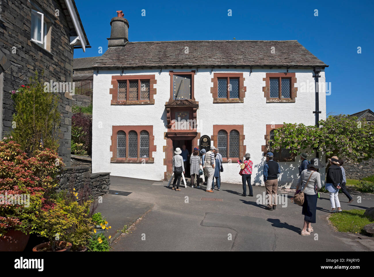 People tourists visitors outside The Old Grammar School Museum (formerly attended by William Wordsworth) Hawkshead Cumbria England UK Britain Stock Photo