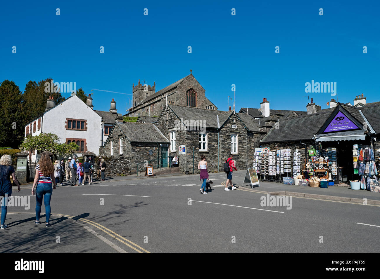 People tourists visitors walking around Hawkshead village in summer