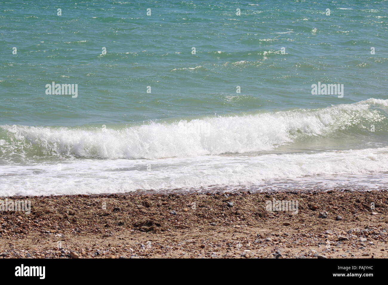Tide coming in on pebble beach Stock Photo Alamy