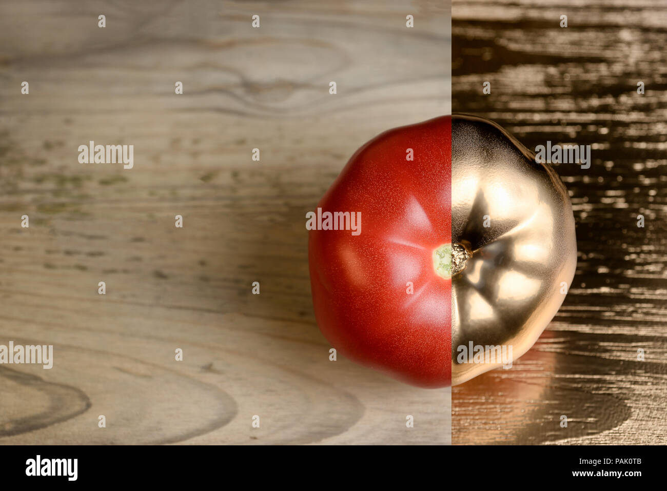 tomato on a wooden table with gold paint Stock Photo