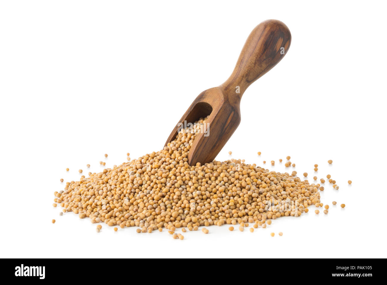Heap of raw, unprocessed mustard seed kernels with wooden scoop on white background Stock Photo