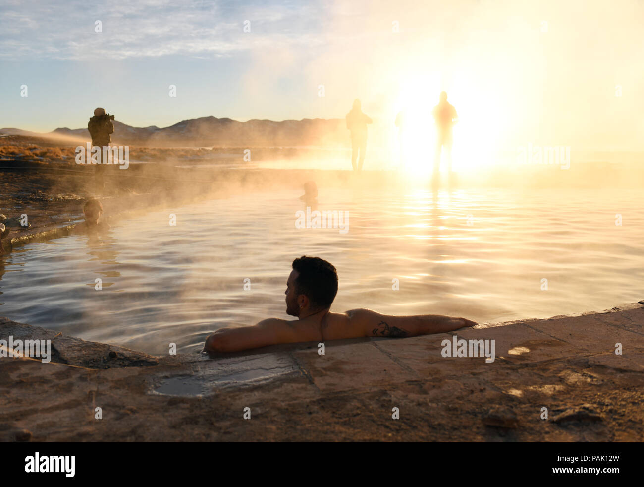 Man soaking in steaming hot springs. The small pool of Termas de Polques is 29C while outside it was -4C. Near Cerro Polques in Bolivia, South America Stock Photo