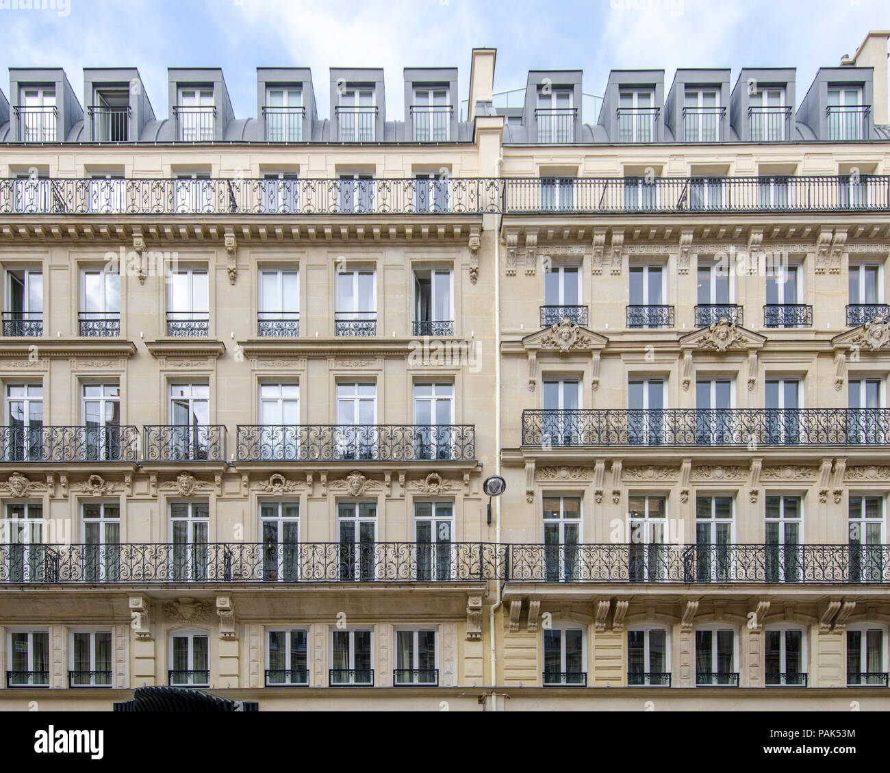 Typical Parisian building elevations in this wonderful European city with large windows and classic details made of stone and iron on a straight persp Stock Photo