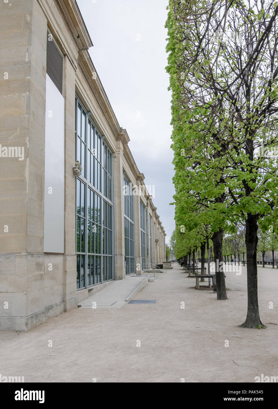 Perspective of a facade of the Musée de l'Orangerie (Orangerie museum) in Paris, France, and trees perfectly cut on a cloudy day Stock Photo