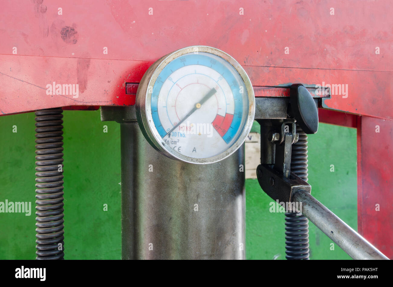 Pressure gauge on an industrial press with a greasy look suggesting tools Stock Photo