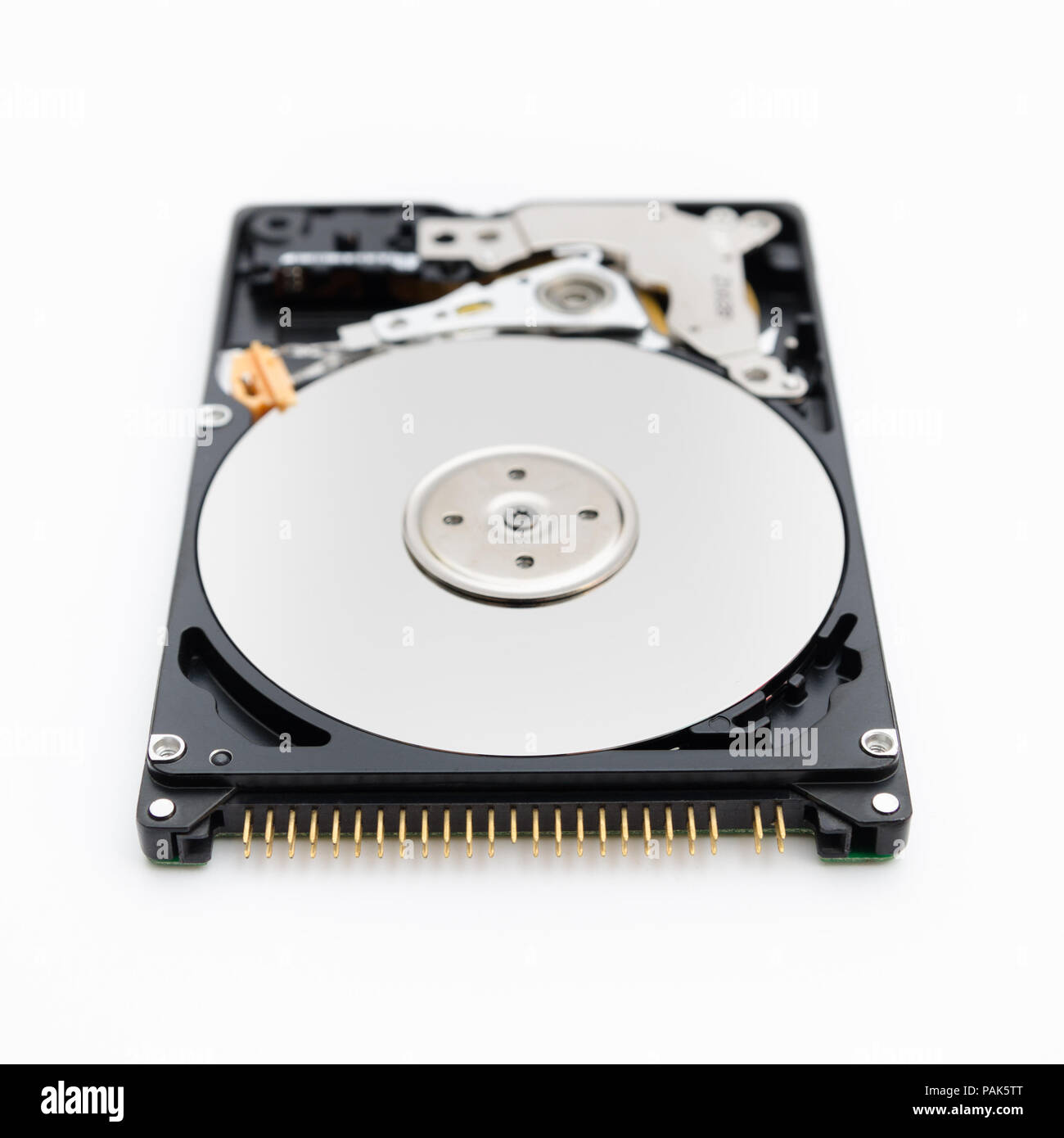 Open hard disk drive on a white siolated background in a close look in an imposing serious perspective showing the disks and the blurred writing head Stock Photo
