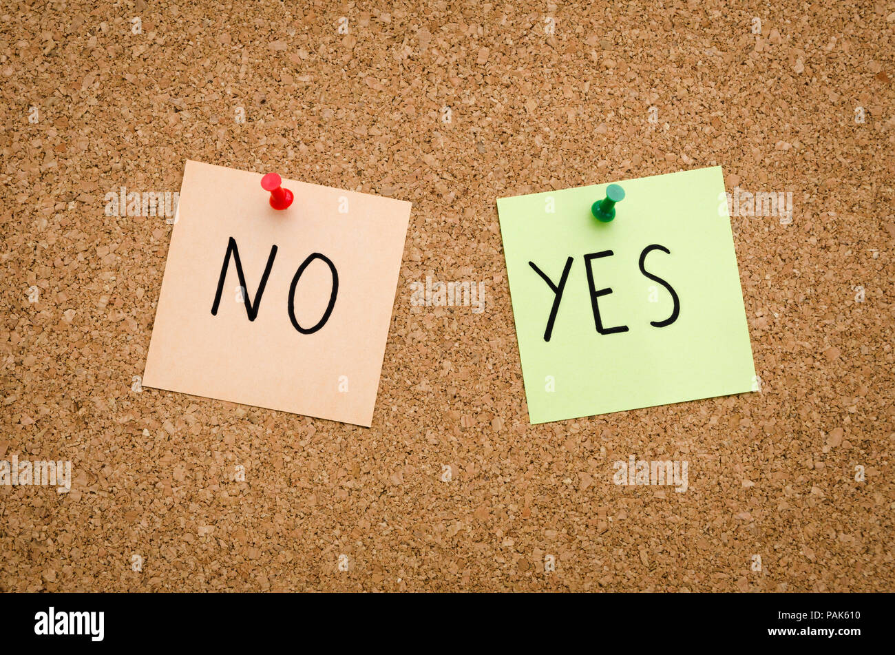 YES NO written on red white and green post notes pinned to a board suggesting options to accept or deny in a bussines look in landscape mode Stock Photo
