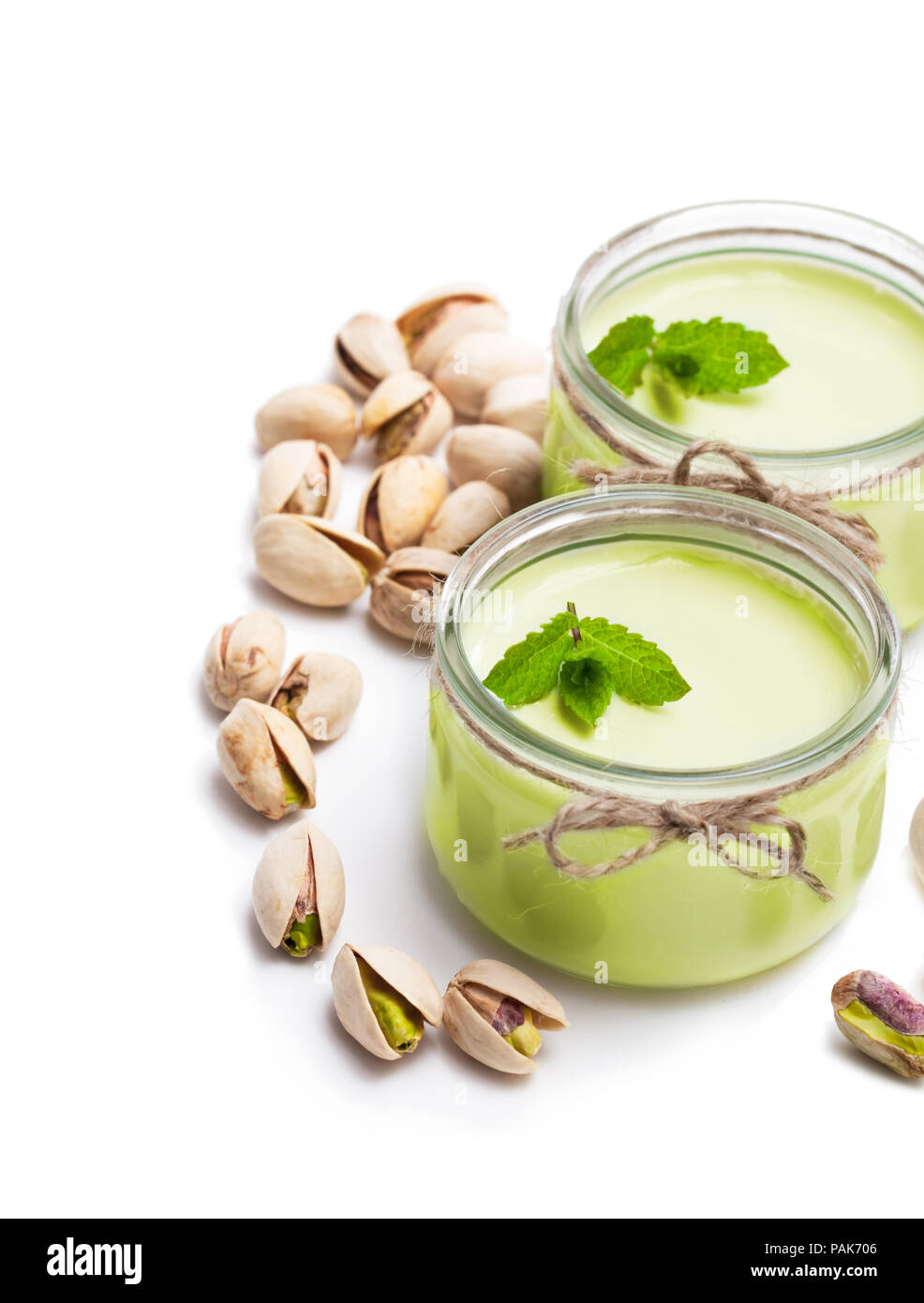 Natural pistachio yogurt in a small glass jar isolated on white Stock