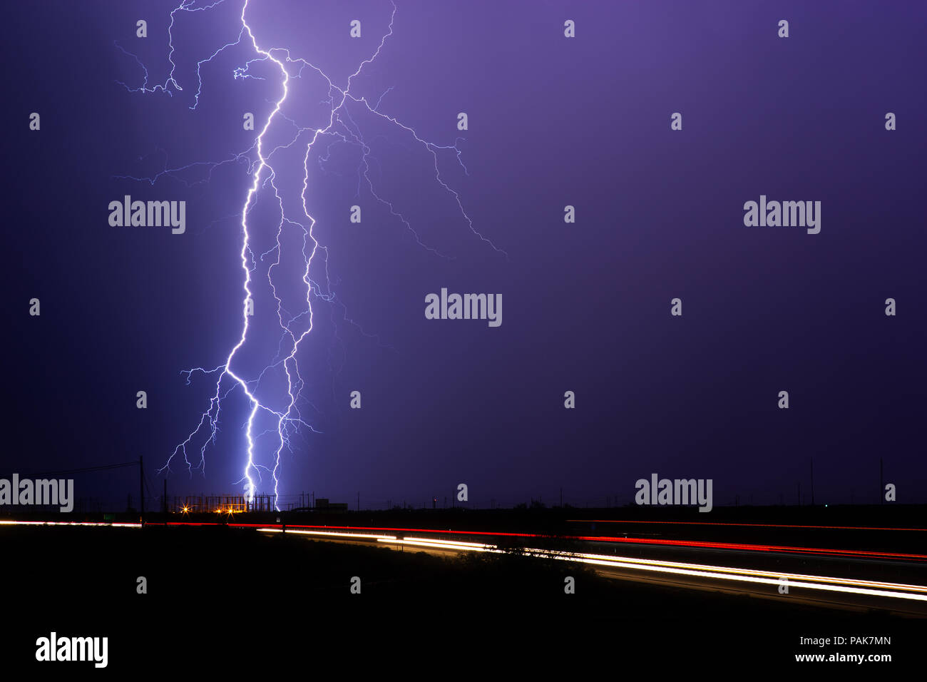 A pair of lightning bolts strike an electrical substation during a nighttime thunderstorm in Tucson, Arizona Stock Photo