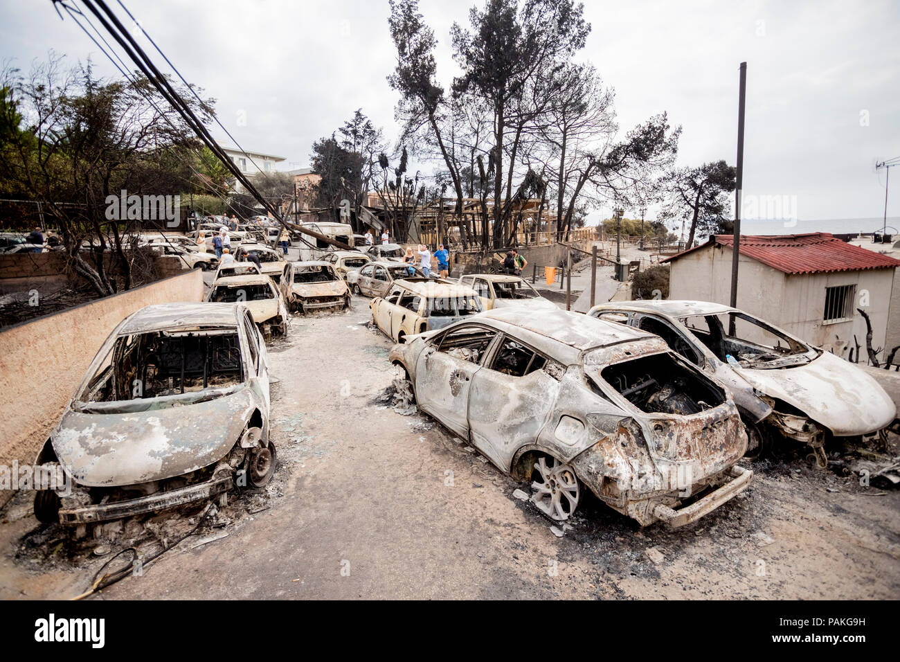 Mati, Greece. 24th July, 2018. Burnt cars stand on the road after a fire  raged there last night. According to new information, the out-of-control  forest fires near Athens killed several people on