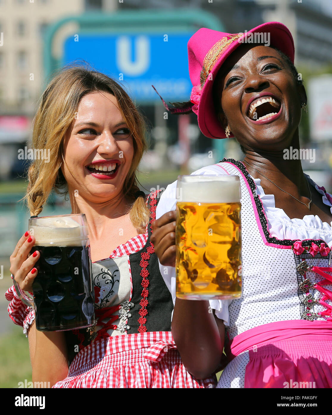 Berlin, Germany. 24th July, 2018. Models Ayanna (r) and Jacquline present draught beer during a photo shoot for the 22nd International Berlin Beer Festival on Karl-Marx-Allee in the district of Friedrichshain-Kreuzberg. The beer festival will take place from 03 to 05 August 2018, between Frankfurter Tor and Strausberger Square. Credit: Wolfgang Kumm/dpa/Alamy Live News Stock Photo