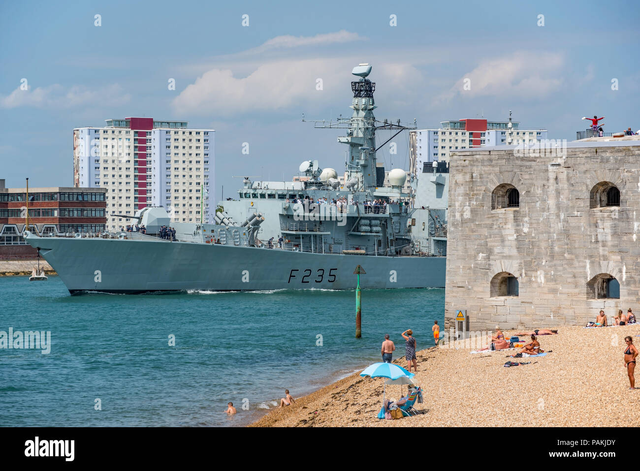 Portsmouth, UK. 24th July, 2018. The British Royal Navy Type 23 Frigate HMS Monmouth appears to be carrying invited guests as it passes sunbathers on the beach. Credit: Neil Watkin / Alamy Live News Stock Photo