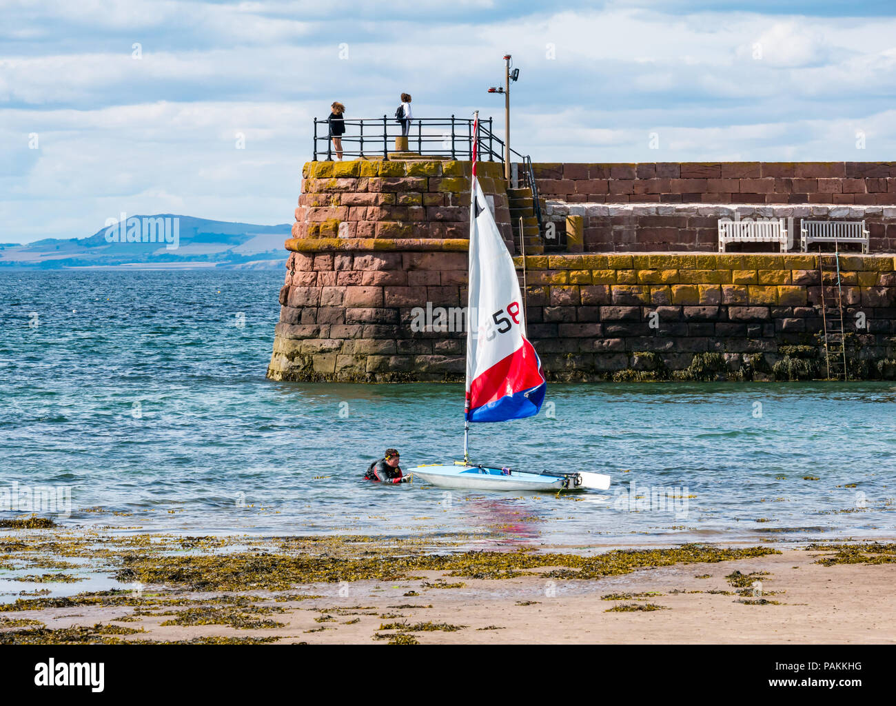North Berwick, East Lothian, Scotland, United Kingdom, 24th July 2018. UK weather:  A sailing dinghy being brought out of the sea on West bay beach Stock Photo