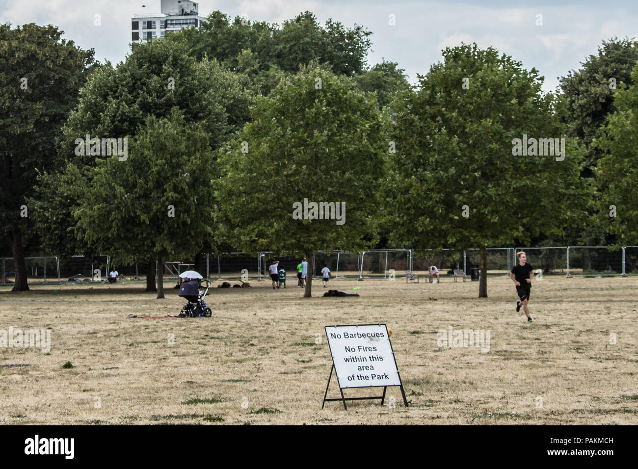 London,UK. 24 July, 2018. 'No Barbecues, no fires within this area of the park'.  London gets some respite with some cloud but still no rain in parched South London where the grass in Burgess park looks more like sand. David Rowe/Alamy Live News. Stock Photo