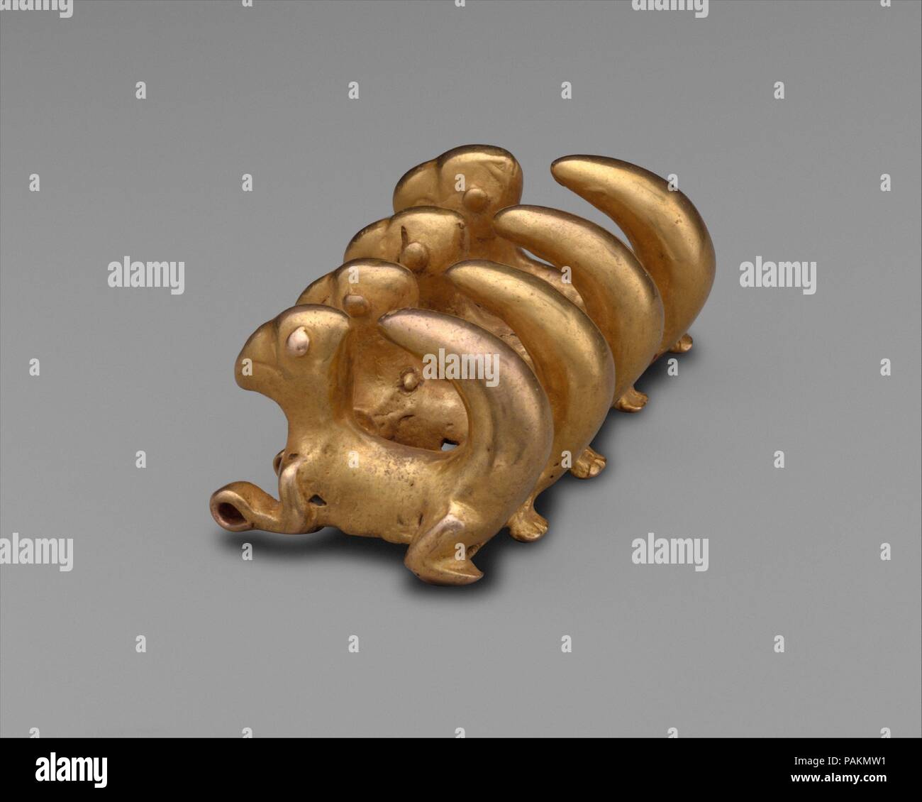 Curly-Tailed Animal Pendant. Culture: Chiriquí (?), Initial Style. Dimensions: H. 1 1/4 × W. 2 3/4 × D. 1 1/2 in. (3.2 × 7 × 3.8 cm). Date: A.D. 100-500.  This pendant, assigned to the Initial Style of the early first millennium AD, features four contiguous creatures, their wide tails arching over their backs.     Este colgante, asignado al Estilo Inicial del primer milenio d. C., presenta cuatro seres contiguos, con colas anchas arqueadas sobre sus espaldas.  <b>Further information</b>  Curly-tailed animals appear on pendants in groups of two, four, or six, though single animals are more comm Stock Photo