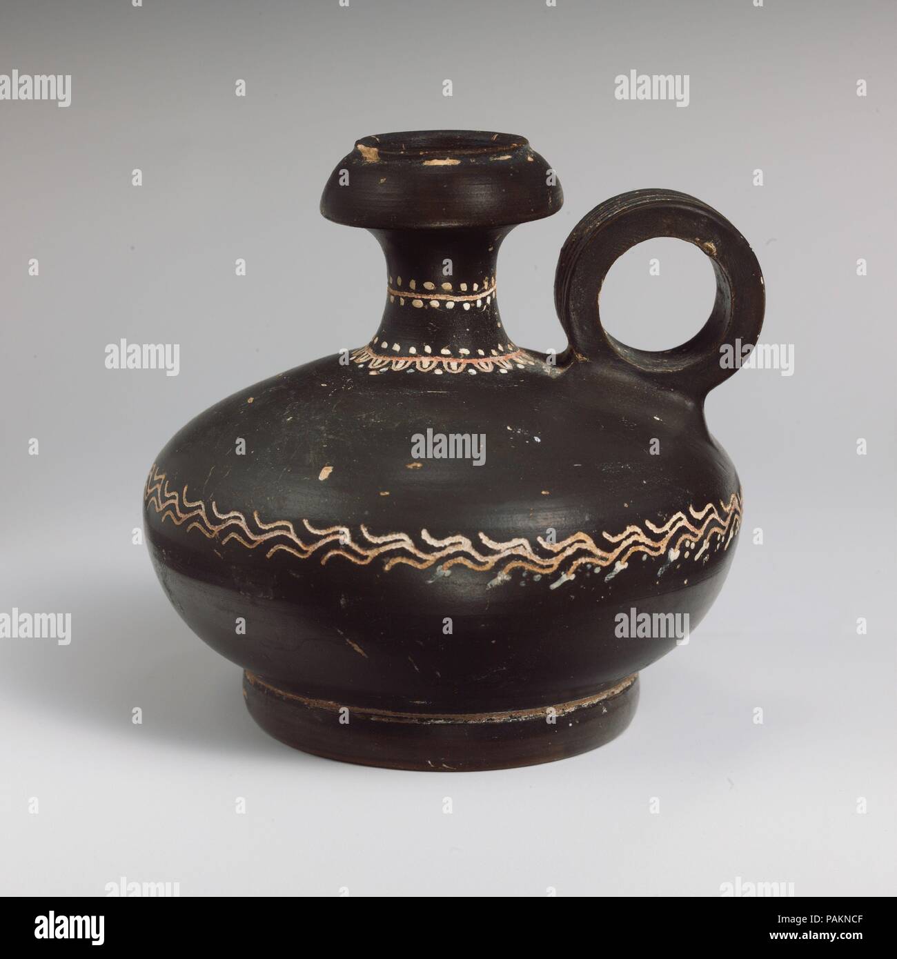 Terracotta squat lekythos (oil flask). Culture: Greek, South Italian, Campanian, Teano. Dimensions: H. 3 7/8 in. (9.8 cm). Date: ca. 330-300 B.C..  Decorated with ivy vine. Museum: Metropolitan Museum of Art, New York, USA. Stock Photo