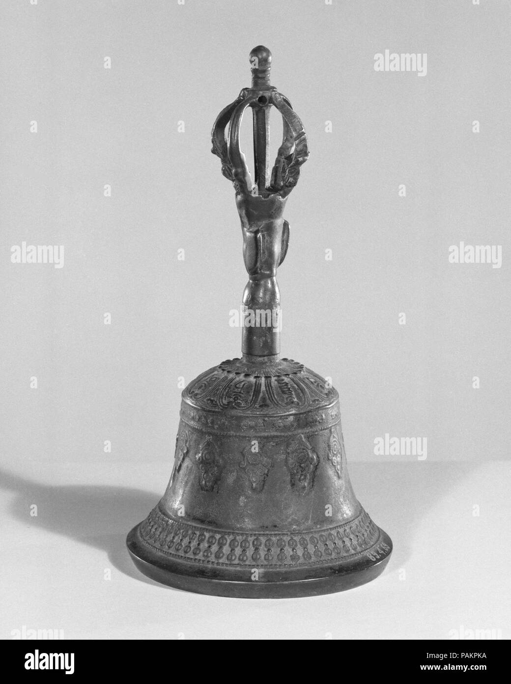 Dril-bu. Culture: Tibetan. Dimensions: H.: 20.3 cm (8 in.); Diam.; 9.5 cm (3-3/4 in.). Date: late 19th century.  The dril-bu (bell) along with the dorje (scepter) are indispensable liturgical instruments used during Buddhist ritual recitation. They are usually regarded as one object, are matched and used together. The bell is held in the left hand and the scepter in the right as both hands gracefully move in prescribed gestures that serve as a commentary to the recitation. As a pair, they reflect the two aspects of Buddhist practice: method and wisdom, intuition and compassion. The prongs emer Stock Photo