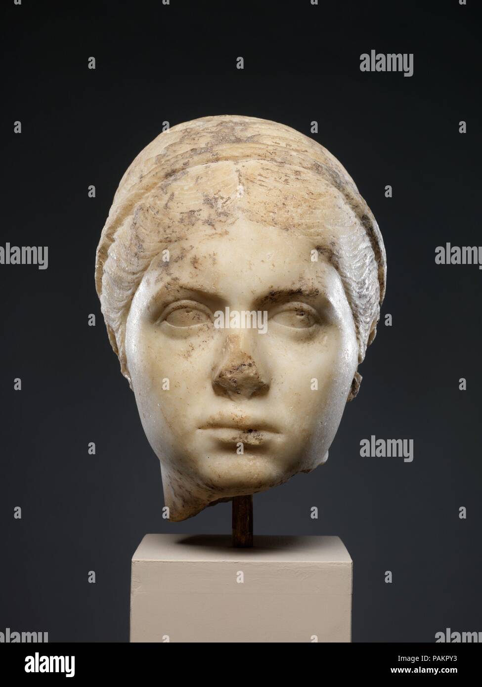 Marble portrait of a young woman. Culture: Roman. Dimensions: H. 10 1/8 in. (25.7 cm). Date: ca. A.D. 139-150.  This girl's hair in a braided coil toward the back of the head imitates the style worn by Faustina the Younger, wife of the emperor Marcus Aurelius (r. A.D. 161-180), as she is depicted on coins as late as A.D. 140-150. Museum: Metropolitan Museum of Art, New York, USA. Stock Photo