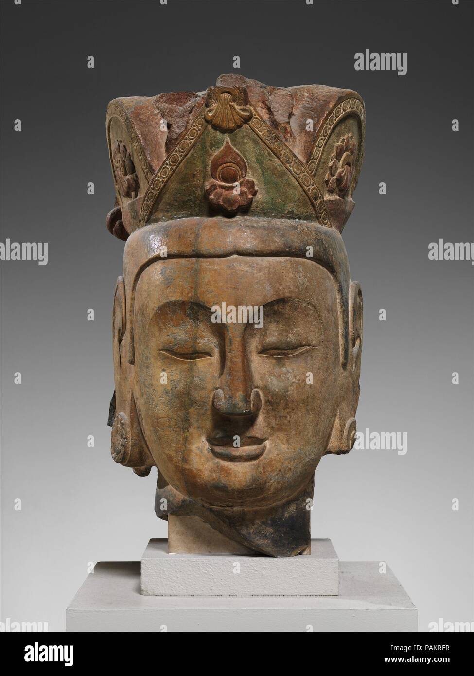 Head of an Attendant Bodhisattva. Culture: China. Dimensions: H. 32 in. (81.3 cm); W. 17 1/2 in. (44.5 cm); approx. D. 12 in. (30.5 cm). Date: ca. 565-75.  This head once belonged to a towering bodhisattva who presided over the entrance to the Central Cave at Northern Xiangtangshan. This site, which consists of only three cave temples with colossal figural sculptures, was once strategically located on the route between the capital at Ye and Jinyang, in Shanxi province. At the beginning of the Northern Qi period, it may have been a place for meditation or other Buddhist activities. Museum: Metr Stock Photo