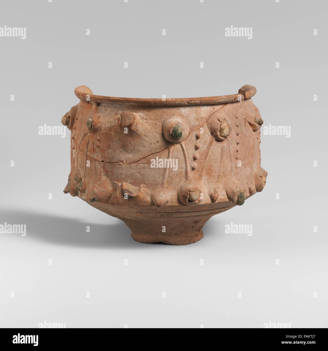 Fragmentary terracotta cup. Culture: Roman. Dimensions: H.  8.31 cm.. Date: 2nd century A.D..  On the sides of the cup is barbotine decoration inset with small chunks of colored glass. Museum: Metropolitan Museum of Art, New York, USA. Stock Photo