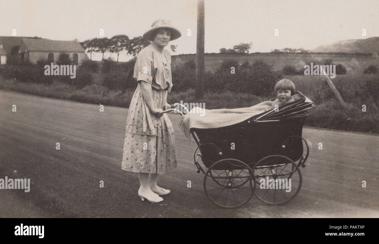 Vintage Photograph of a Lady Pushing a Child in a Pram Stock Photo