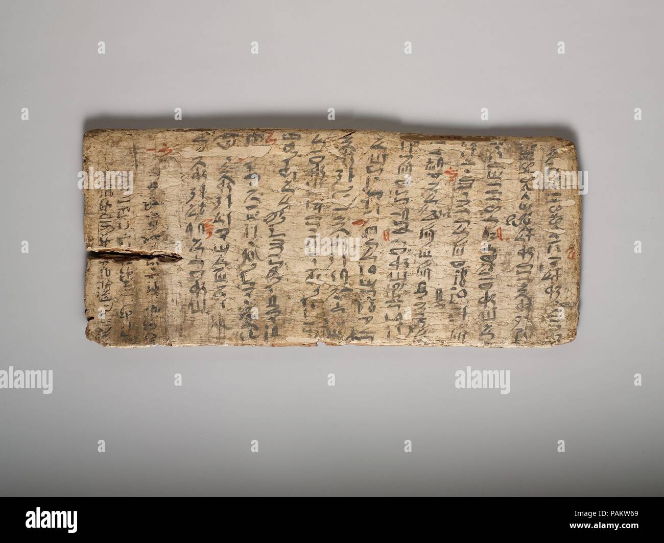 Writing board. Dimensions: L. 43 cm (16 15/16 in); w. 19 cm (7 1/2 in). Dynasty: Dynasty 12. Date: ca. 1981-1802 B.C..  Gessoed boards were used for writing notes or school exercises. Like the slate writing tablets of yesteryear, they could be used repeatedly, with old texts being whitewashed to provide a 'clean slate' for another. This board still bears traces of earlier writing (at left). The main text is a wordy model letter that the student copied--and surely also was expected to memorize. His many spelling mistakes have been corrected in red ink by the teacher. Museum: Metropolitan Museum Stock Photo