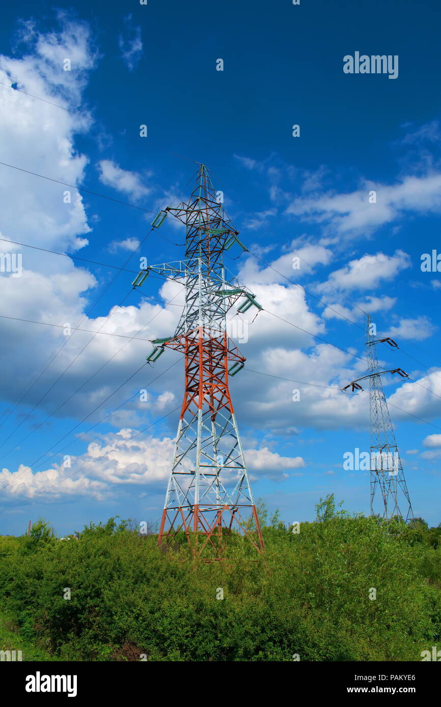 High voltage poles and the blue sky with clouds Stock Photo - Alamy