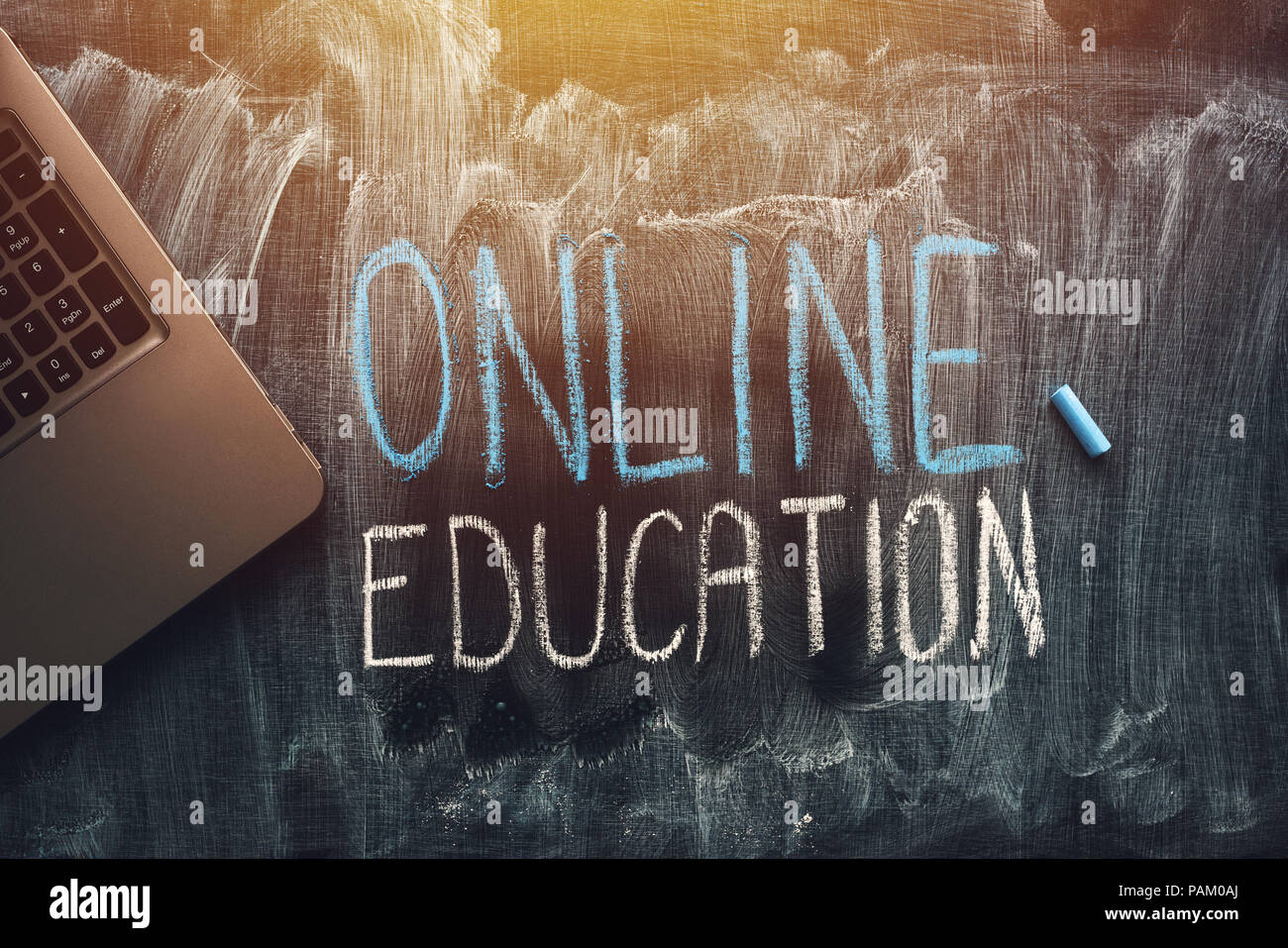 Online education concept with laptop computer over dirty blackboard surface Stock Photo