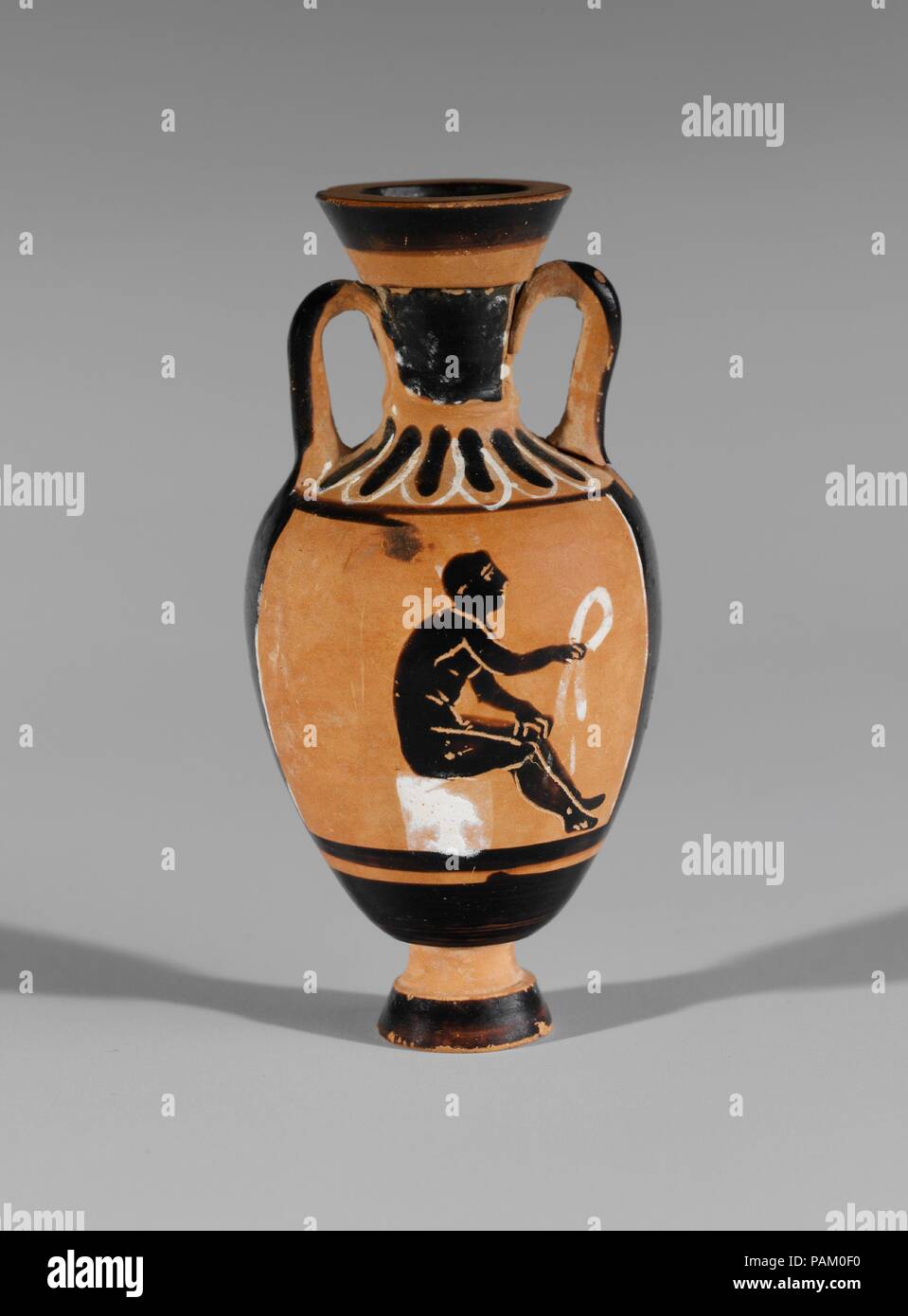 Terracotta miniature Panathenaic amphora. Culture: Greek, Attic. Dimensions: H.: 3 5/16 in. (8.4 cm). Date: ca. 400 B.C..  Obverse, Athena   Reverse, seated athlete  The Bulas Group specialized in miniature versions of Panathenaic prize amphorae. The shape and the representation of Athena follow the models quite closely. The seated athlete holding what might be a fillet is a narrative vignette that would not have appeared on a prize vase. Museum: Metropolitan Museum of Art, New York, USA. Stock Photo