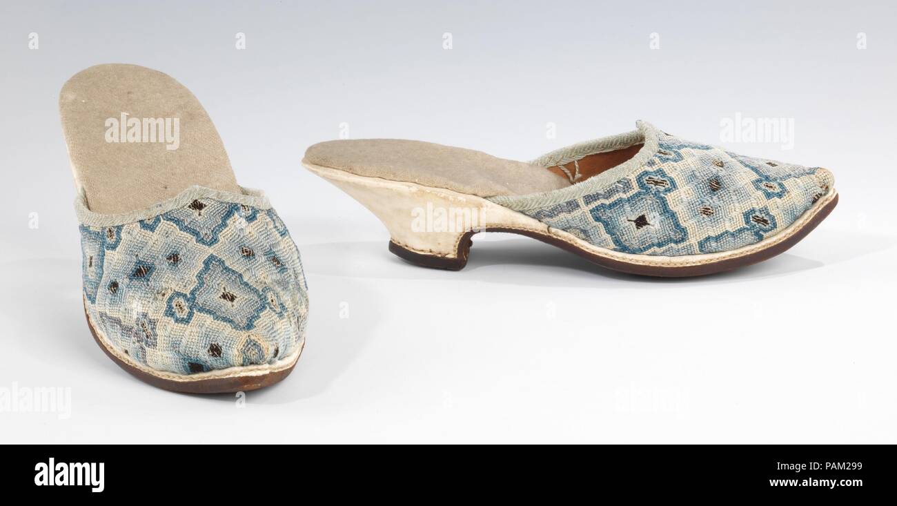 Mules. Culture: European. Date: early 18th century.  Mules were a popular form of at-home footwear in the 17th and 18th centuries for both men and women.  This fairly conservative example of ladies' mules features a low heel and good quality embroidery in tastefully subdued tones.  This style of embroidery is known as Florentine work, a type of flame stitch canvas work with varied stitch lengths. Museum: Metropolitan Museum of Art, New York, USA. Stock Photo